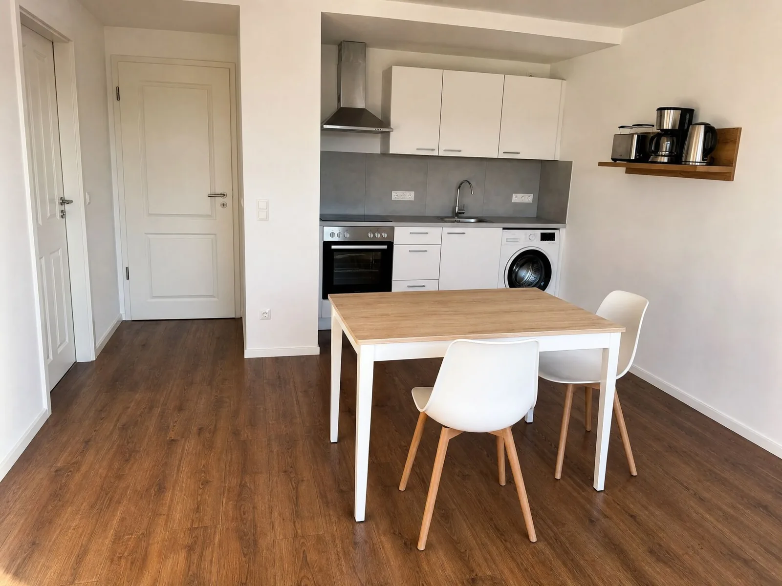 Küche mit Esstisch, Backofen und Waschmaschine in einer möblierten Wohnung in Erfurt