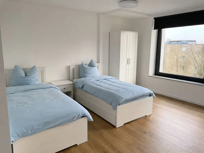Helles Zweibettzimmer mit zwei Einzelbetten und Blick ins Grüne
